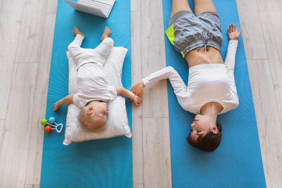 baby and mom stretching on a yoga mat